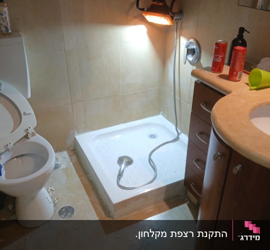 התקנת אגנית למקלחון בחדר רחצה במהלך עבודת אינסטלציה